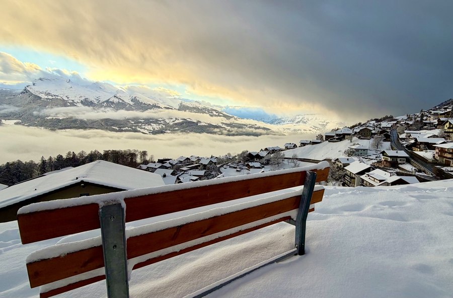 Bank im Schnee mit weitem Blick über Liechtenstein
