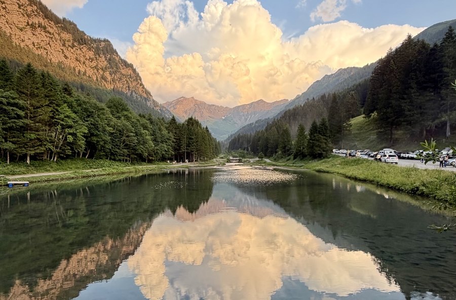 Berge und Wolken spiegeln sich in ruhigem Wasser